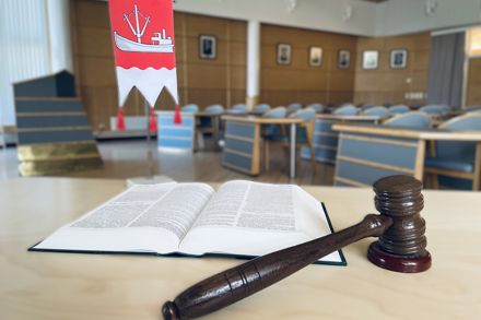 Valtuustosalin pöydällä avoin kirja, puinen nuija ja Taipalsaaren pöytävaakuna.