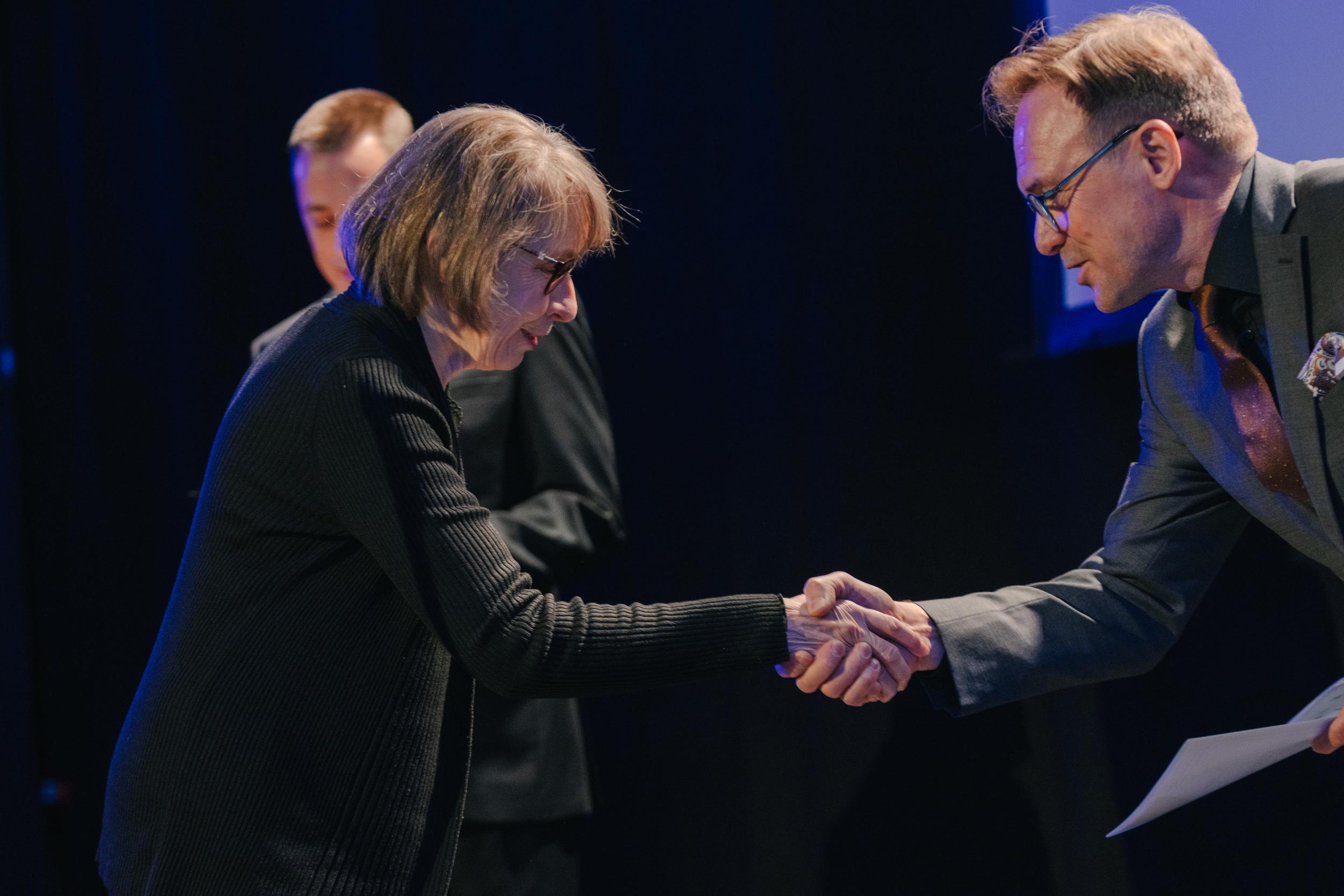 Mies ja nainen kättelevät.