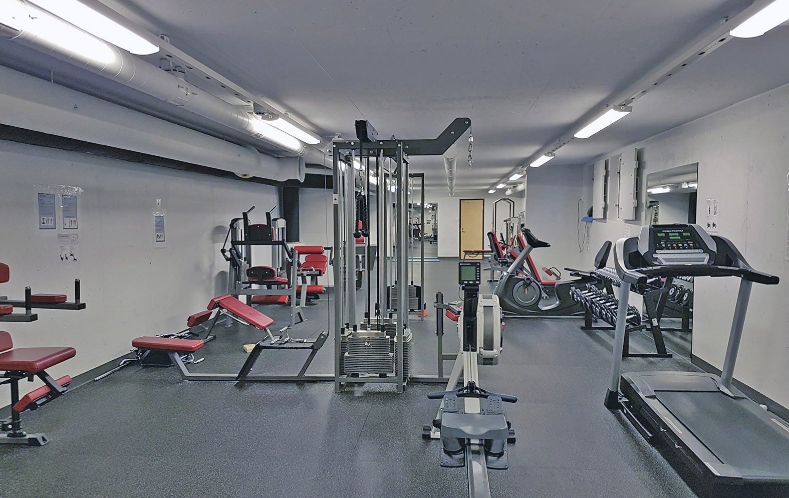 Erilaisia kuntosalilaitteita.